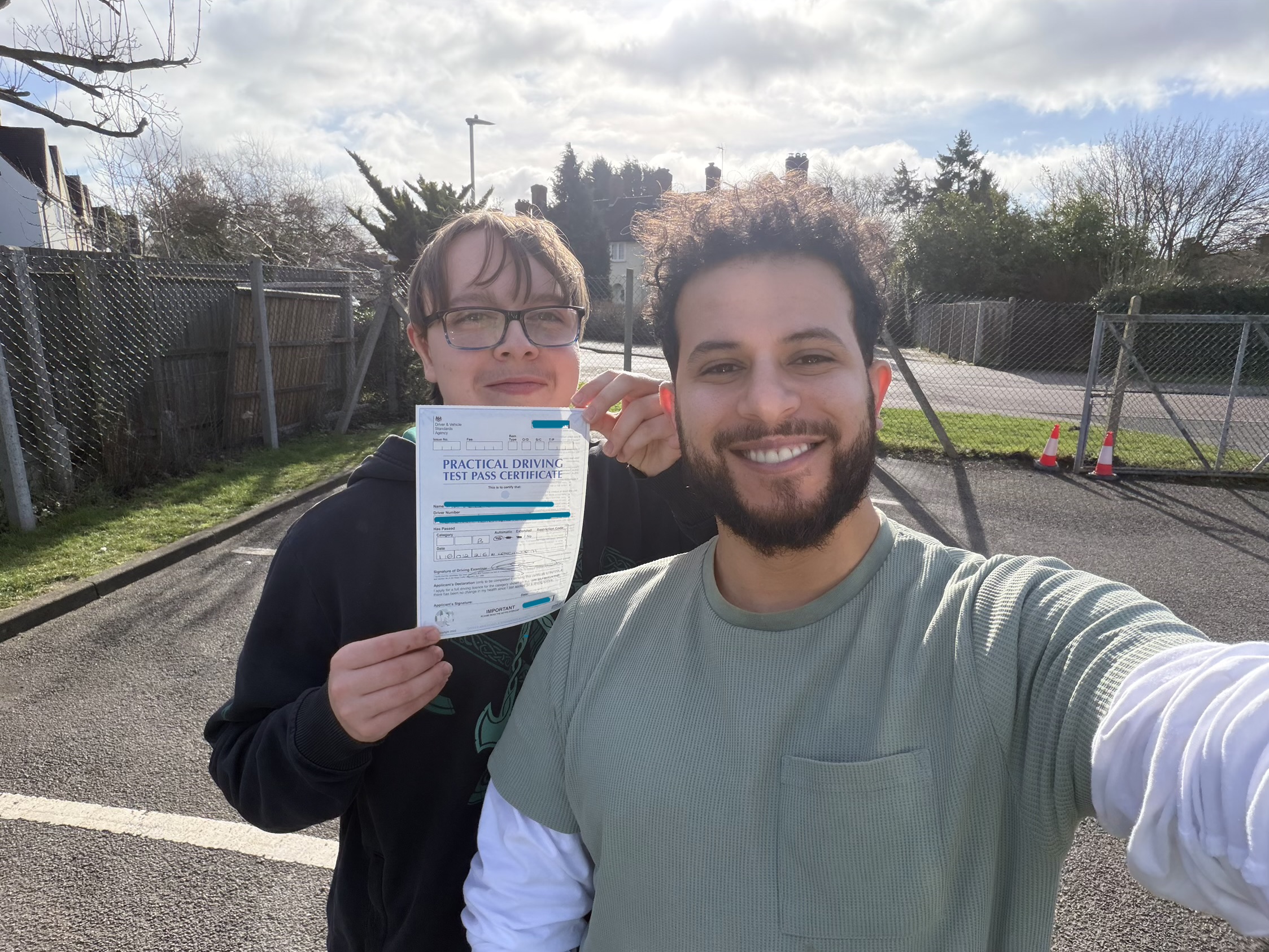Student proudly holding their driving test pass certificate